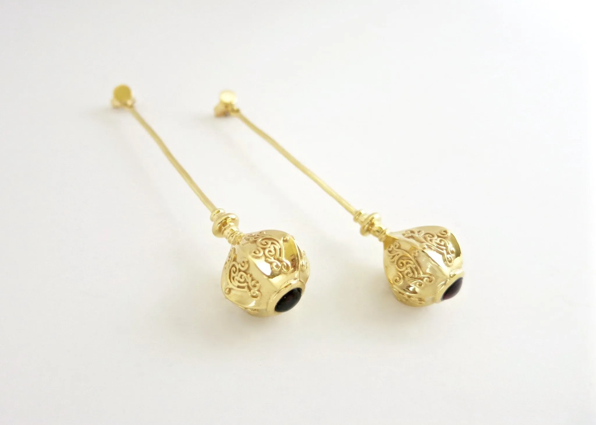 Elegant, stylish, gold plated long earrings with filigree work and garnet accent