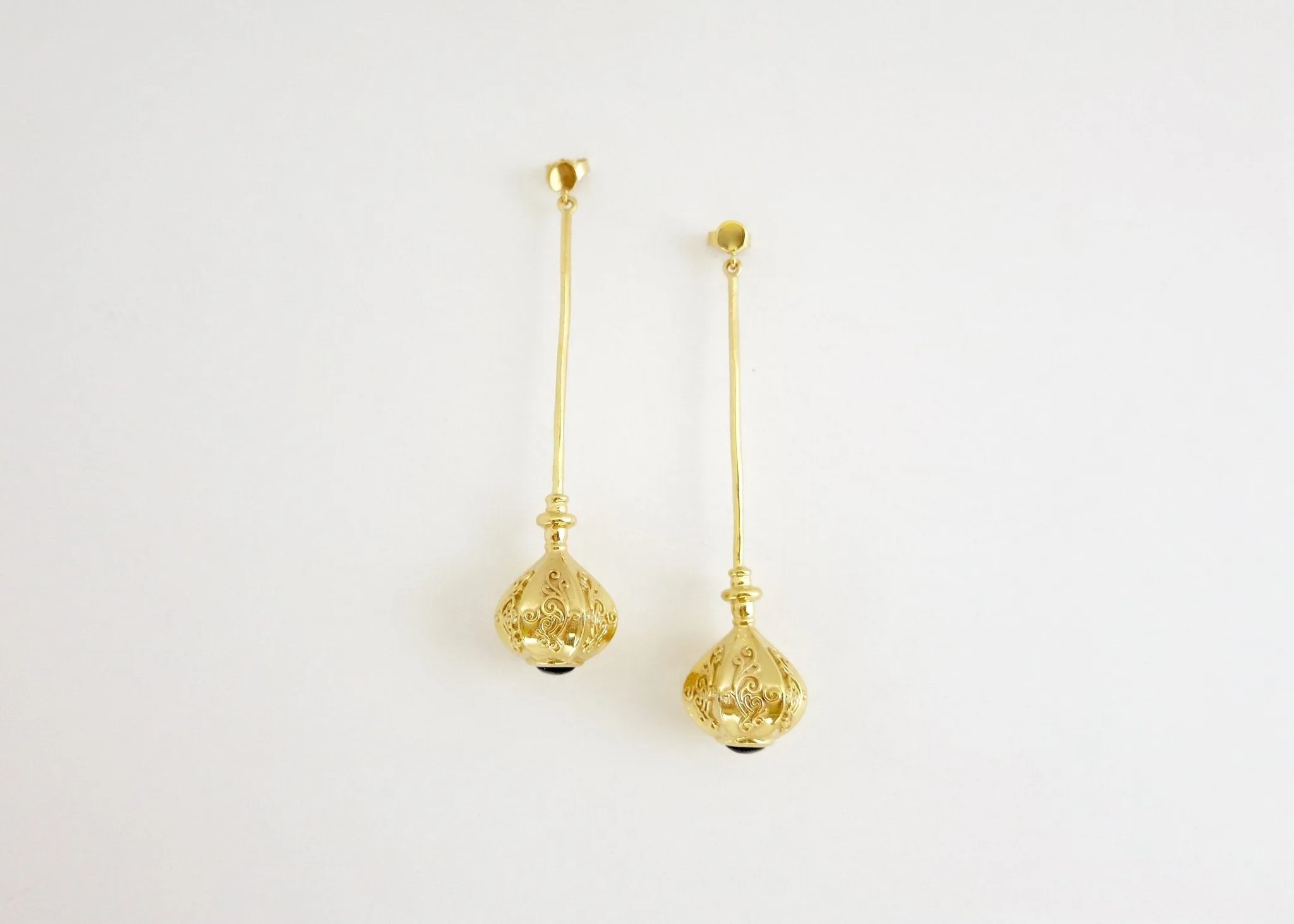 Elegant, stylish, gold plated long earrings with filigree work and garnet accent